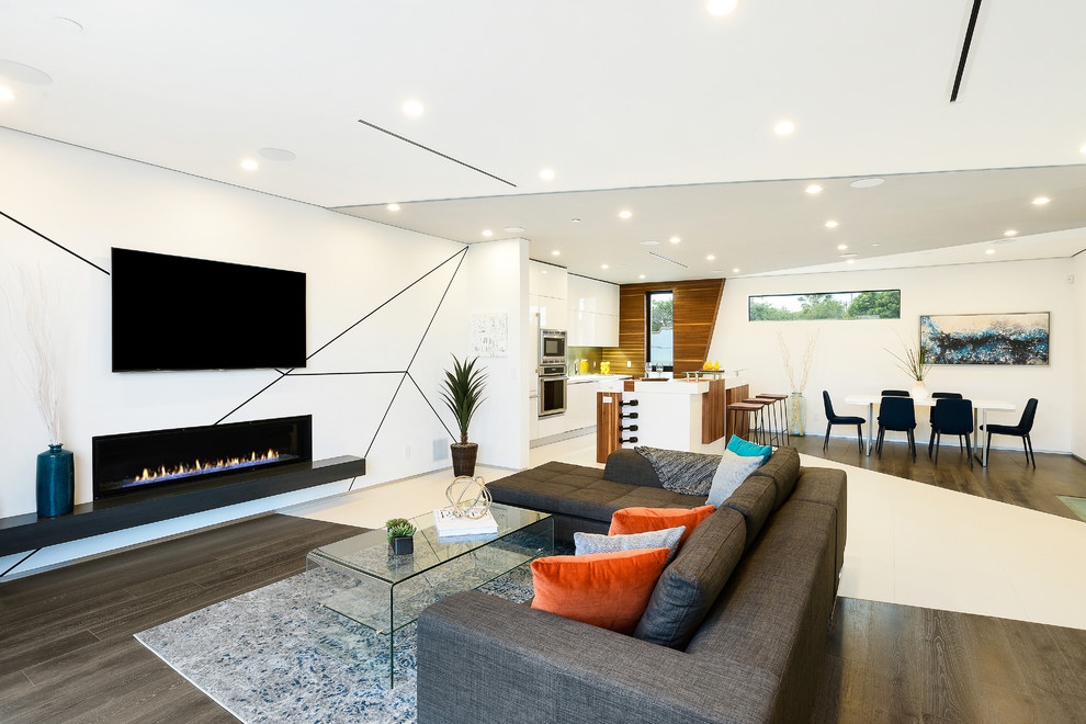Inspiration for a mid-sized contemporary open concept family room in Los Angeles with multi-coloured walls, dark hardwood floors, a ribbon fireplace, a wall-mounted tv, a plaster fireplace surround and brown floor.