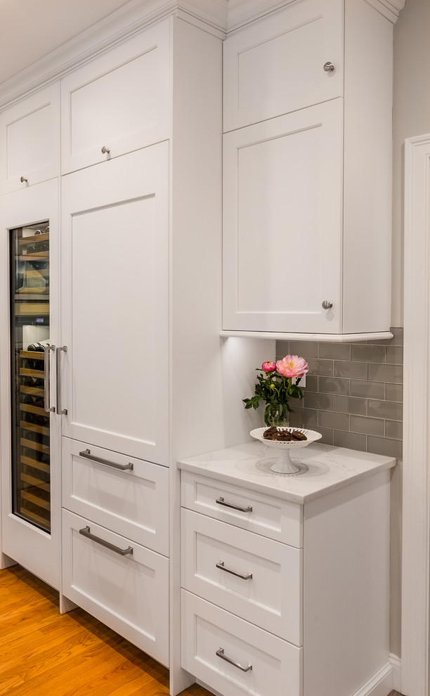 Eat-in kitchen - transitional u-shaped eat-in kitchen idea in Providence with an undermount sink, white cabinets, quartzite countertops, glass tile backsplash, stainless steel appliances and an island