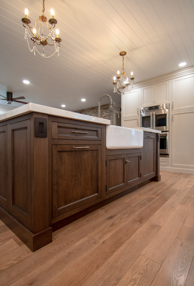 Kitchen - transitional medium tone wood floor, brown floor and shiplap ceiling kitchen idea with a farmhouse sink, shaker cabinets, dark wood cabinets, quartz countertops, stainless steel appliances, an island and white countertops