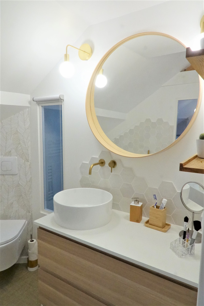 Cette photo montre une petite salle d'eau moderne en bois clair avec un placard à porte affleurante, une baignoire posée, WC suspendus, un carrelage blanc, des carreaux de porcelaine, un mur blanc, un sol en vinyl, un lavabo posé, un plan de toilette en stratifié, un sol beige, un plan de toilette blanc, une fenêtre, meuble simple vasque, meuble-lavabo sur pied, poutres apparentes et du papier peint.