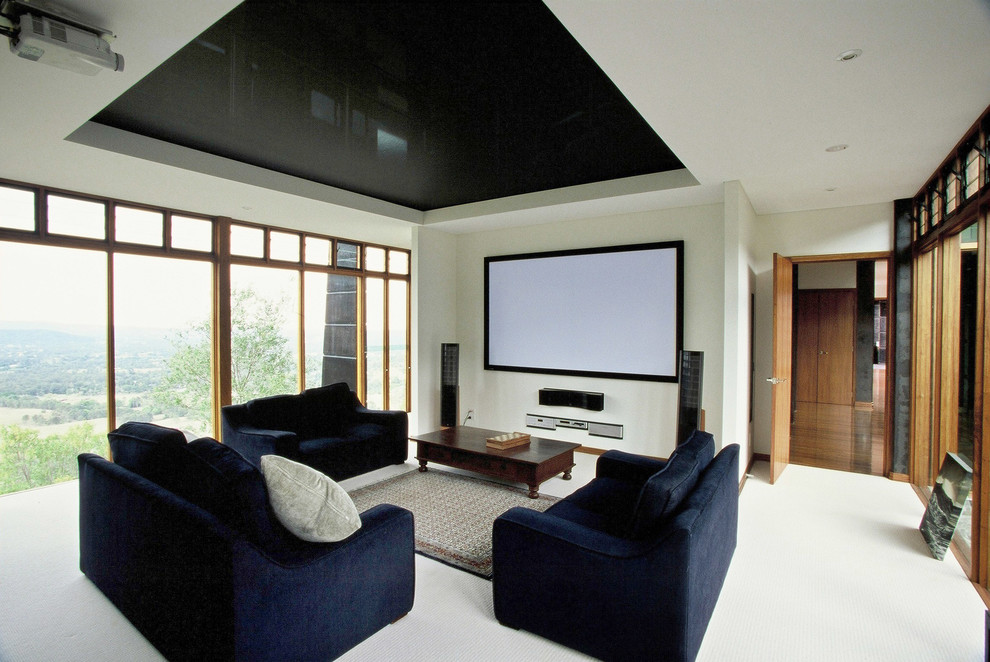Photo of an expansive modern open concept home theatre in Brisbane with white walls, carpet, a projector screen and white floor.