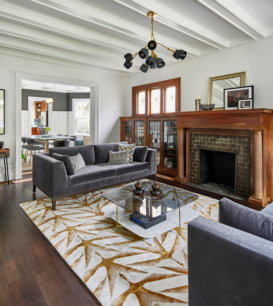 This is an example of a medium sized bohemian enclosed living room in New York with white walls, dark hardwood flooring, a standard fireplace, a tiled fireplace surround, yellow floors and a coffered ceiling.