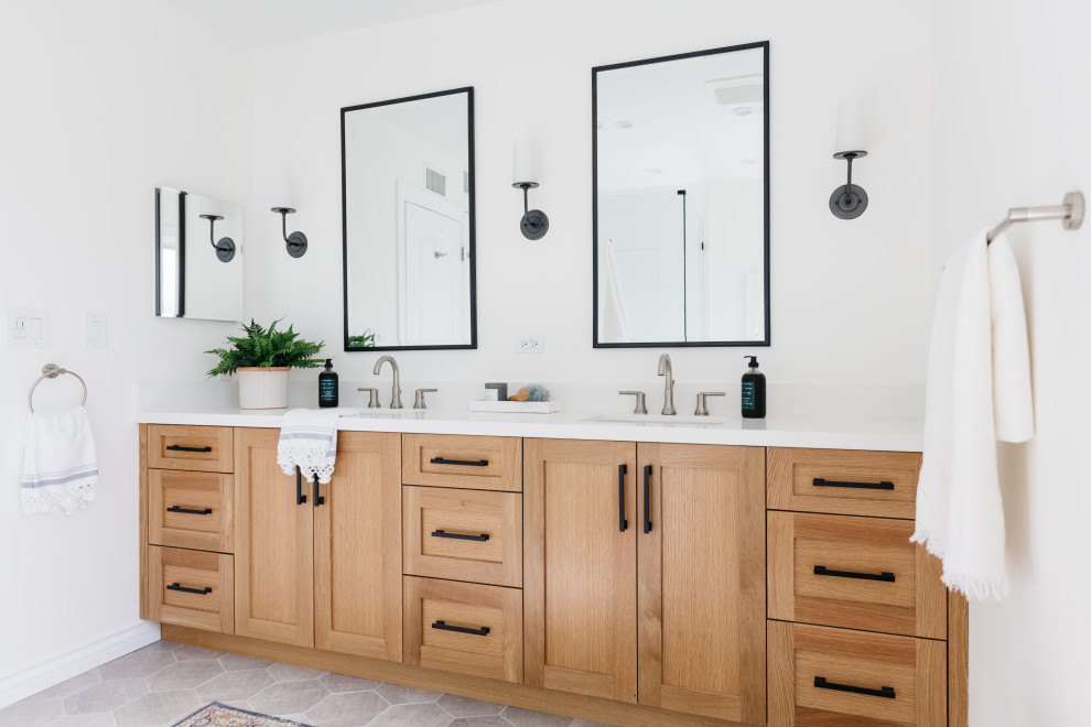 Transitional master bathroom in Los Angeles with shaker cabinets, light wood cabinets, a corner shower, white tile, white walls, porcelain floors, an undermount sink, engineered quartz benchtops, grey floor and white benchtops.