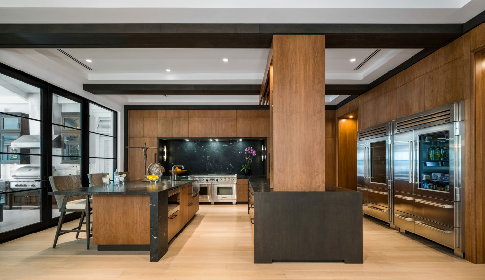 Inspiration for a large transitional l-shaped light wood floor, beige floor and coffered ceiling open concept kitchen remodel in Miami with a drop-in sink, flat-panel cabinets, brown cabinets, marble countertops, black backsplash, marble backsplash, stainless steel appliances, two islands and black countertops