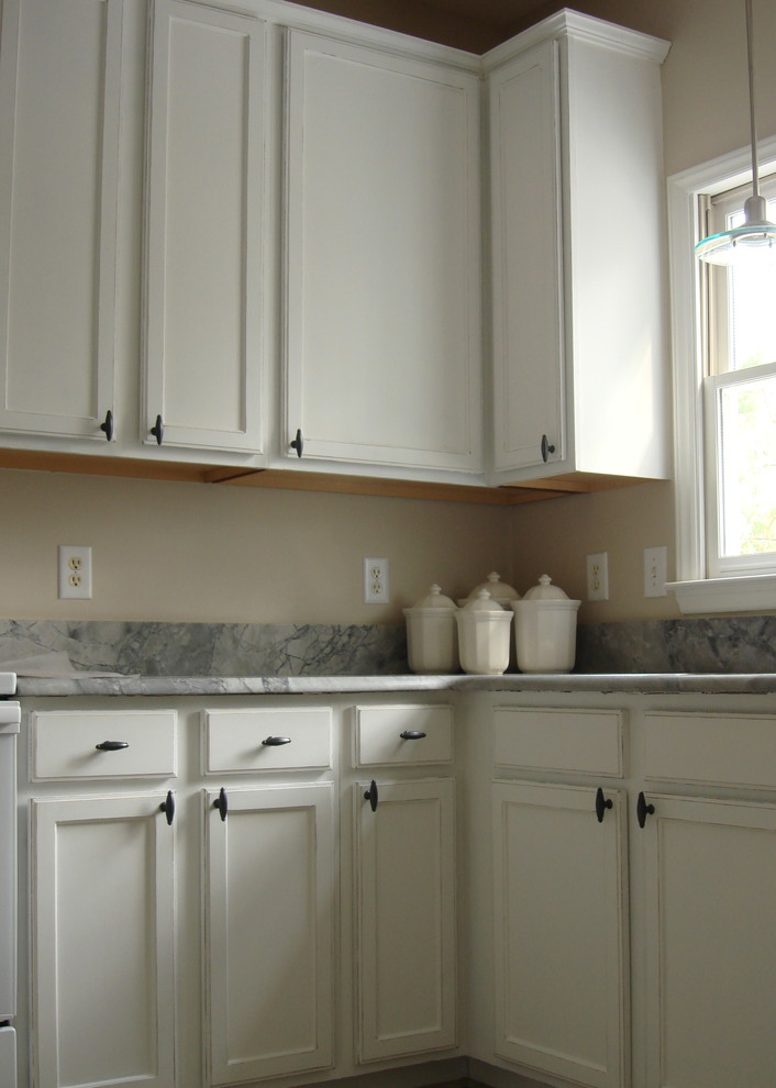 Photo of a mid-sized traditional l-shaped eat-in kitchen in Raleigh with an undermount sink, recessed-panel cabinets, white cabinets, granite benchtops, grey benchtop and no island.