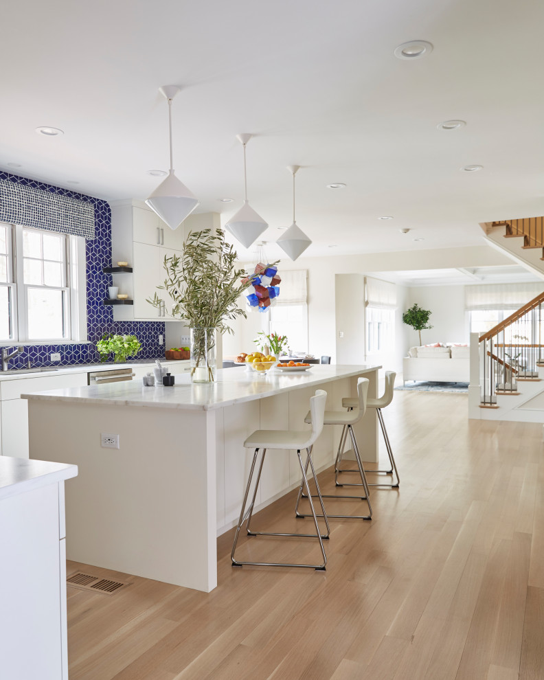 Huge minimalist u-shaped light wood floor and brown floor eat-in kitchen photo in Boston with an undermount sink, flat-panel cabinets, white cabinets, marble countertops, blue backsplash, ceramic backsplash, stainless steel appliances, an island and yellow countertops