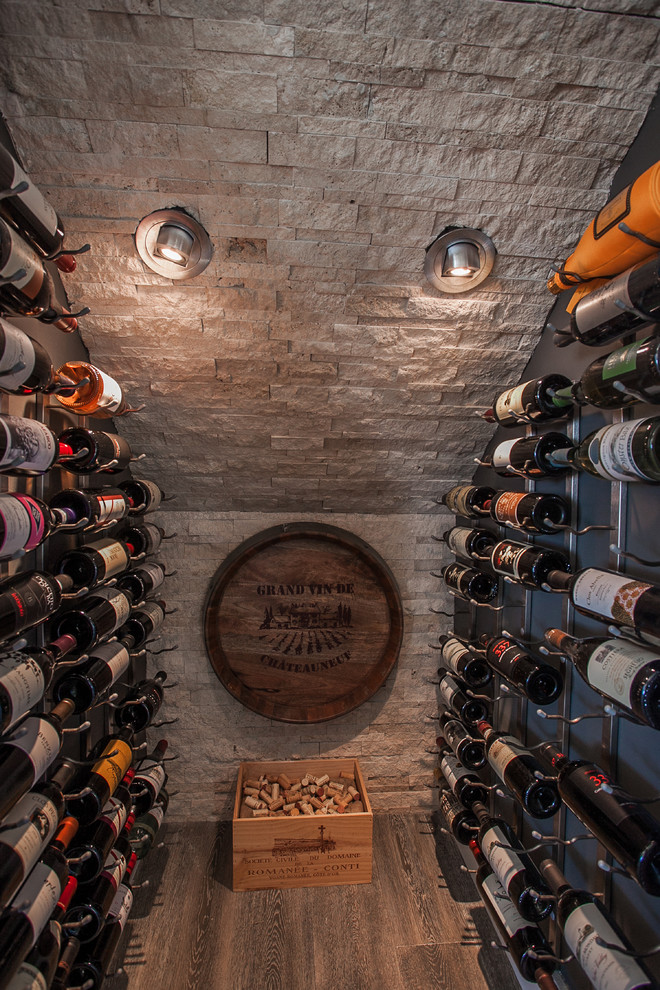 Trendy dark wood floor and gray floor wine cellar photo in Orange County with storage racks