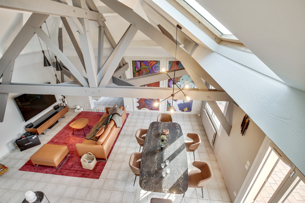 Salle de séjour mansardée ou avec mezzanine?[Exemple de salle de séjour mansardée ou avec mezzanine With un bar de salon, un mur gris, un sol en carrelage de céramique, une cheminée double-face, un manteau de cheminée en plâtre, un téléviseur fixé au mur and un sol gris.]:[Exemple de salles de séjour mansardées ou avec mezzanine With un bar de salon, un mur gris, un sol en carrelage de céramique, une cheminée double-face, un manteau de cheminée en plâtre, un téléviseur fixé au mur and un sol gris.]