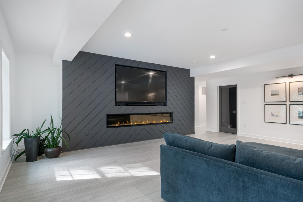 Immagine di un soggiorno minimalista di medie dimensioni e aperto con pareti bianche, pavimento in vinile, cornice del camino in perlinato, parete attrezzata e pavimento grigio