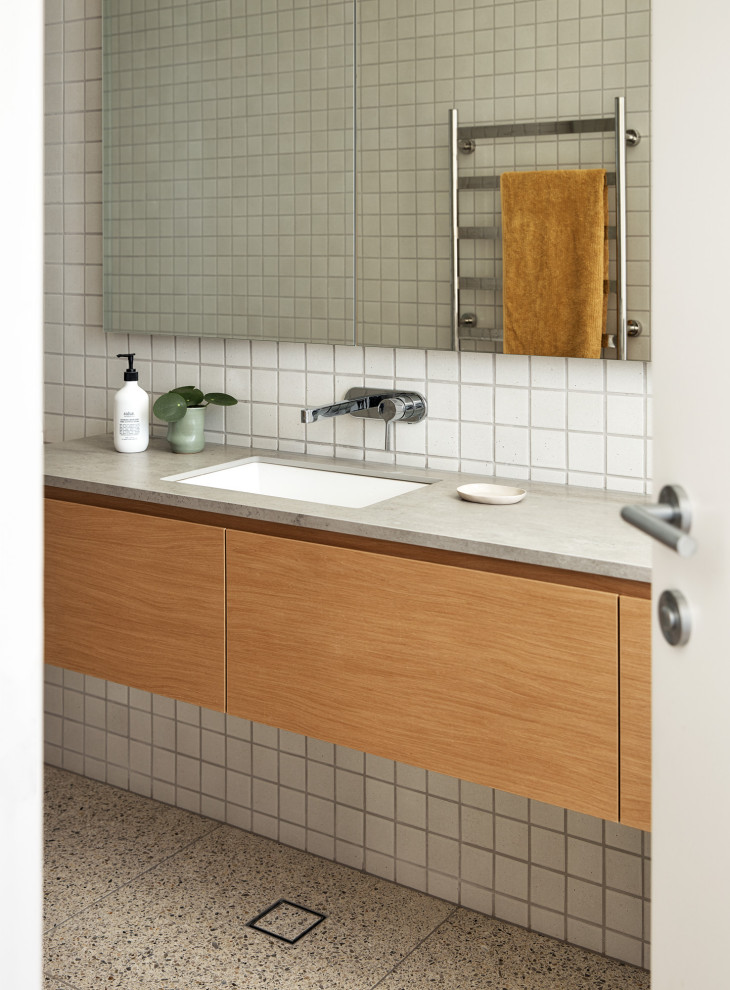Idée de décoration pour une salle de bain design de taille moyenne avec un carrelage blanc, un sol en terrazzo, un lavabo encastré, meuble-lavabo suspendu, des portes de placard grises et meuble simple vasque.