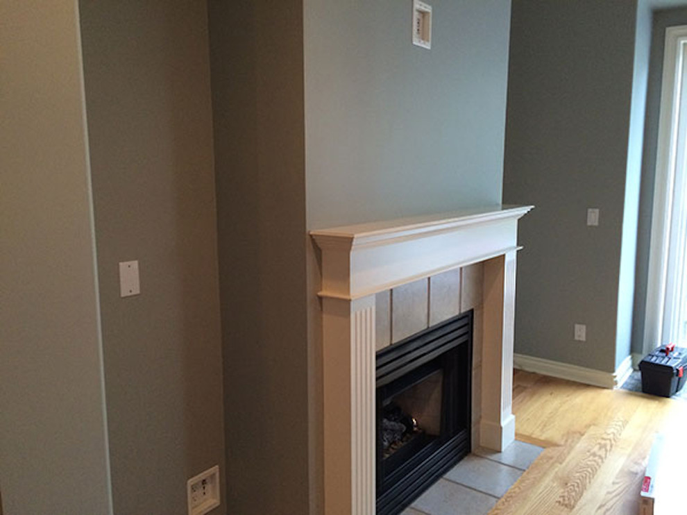 Example of a transitional living room design in Vancouver with beige walls, a standard fireplace and a plaster fireplace