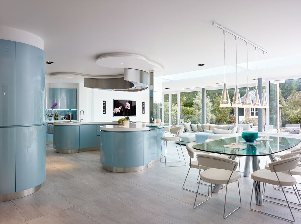 Photo of an expansive modern u-shaped eat-in kitchen in London with an integrated sink, flat-panel cabinets, blue cabinets, solid surface benchtops, blue splashback, glass sheet splashback, stainless steel appliances, marble floors and with island.