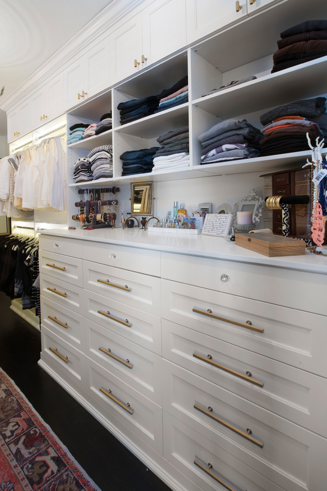 This is an example of a large transitional women's walk-in wardrobe in Chicago with recessed-panel cabinets, white cabinets and dark hardwood floors.