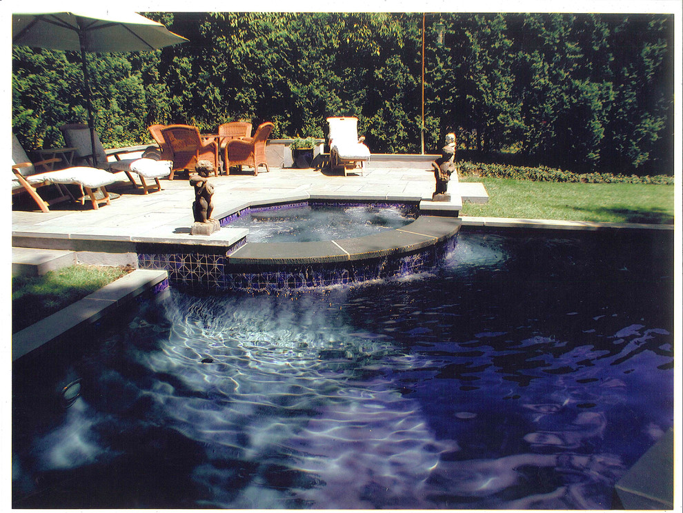 This is an example of a large mediterranean backyard custom-shaped pool in New York with a hot tub.