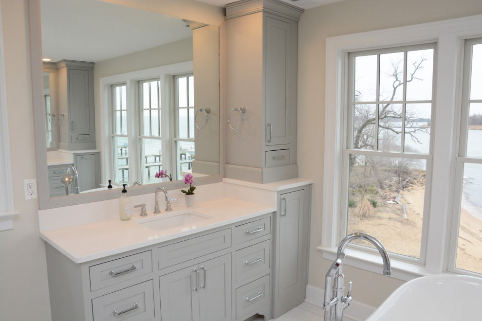 Design ideas for a large classic ensuite bathroom in Baltimore with beaded cabinets, grey cabinets, a freestanding bath, a corner shower, beige walls, a submerged sink, engineered stone worktops, white floors, a hinged door, white worktops, double sinks and a freestanding vanity unit.