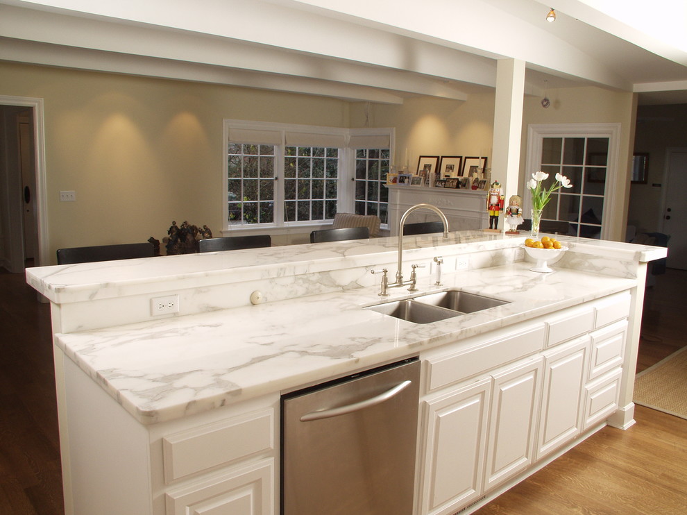 Photo of a traditional galley eat-in kitchen in Seattle with an undermount sink, beaded inset cabinets, white cabinets, marble benchtops, white splashback, stone slab splashback and stainless steel appliances.