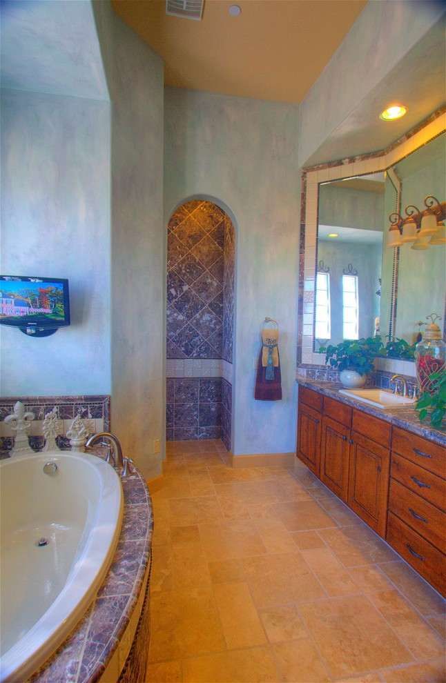 Inspiration for a blue tile drop-in bathtub remodel in Phoenix with tile countertops