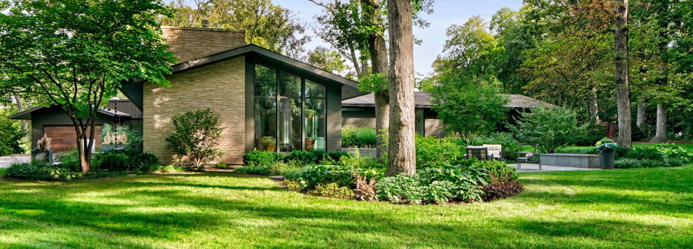 Inspiration for a huge mid-century modern partial sun side yard stone landscaping in Chicago with a fire pit for summer.