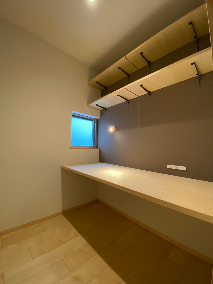 Kleines Modernes Arbeitszimmer mit Arbeitsplatz, brauner Wandfarbe, Sperrholzboden, Einbau-Schreibtisch, beigem Boden, Tapetendecke und Tapetenwänden in Sonstige