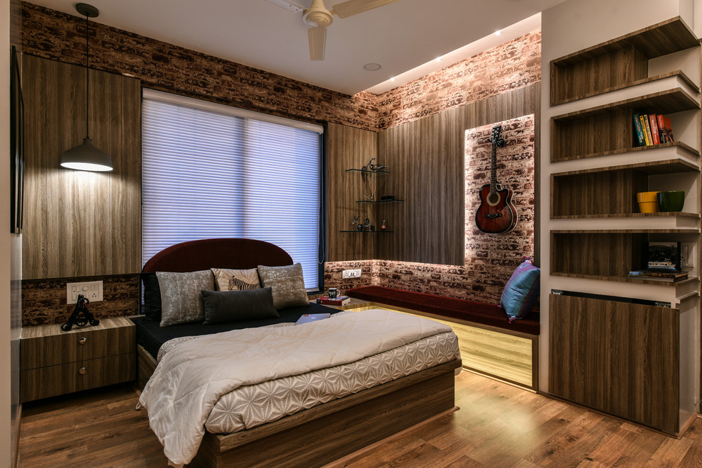 This is an example of a contemporary bedroom in Mumbai with beige walls and medium hardwood floors.