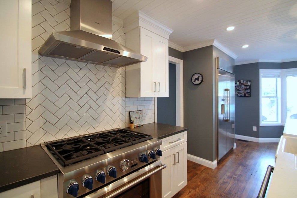 Large transitional u-shaped dark wood floor eat-in kitchen photo in Denver with a farmhouse sink, shaker cabinets, gray cabinets, quartzite countertops, white backsplash, ceramic backsplash, stainless steel appliances and an island