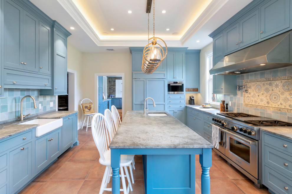 This is an example of a large country l-shaped separate kitchen in Philadelphia with a farmhouse sink, beaded inset cabinets, blue cabinets, soapstone benchtops, blue splashback, ceramic splashback, panelled appliances, porcelain floors, with island, orange floor, black benchtop and recessed.