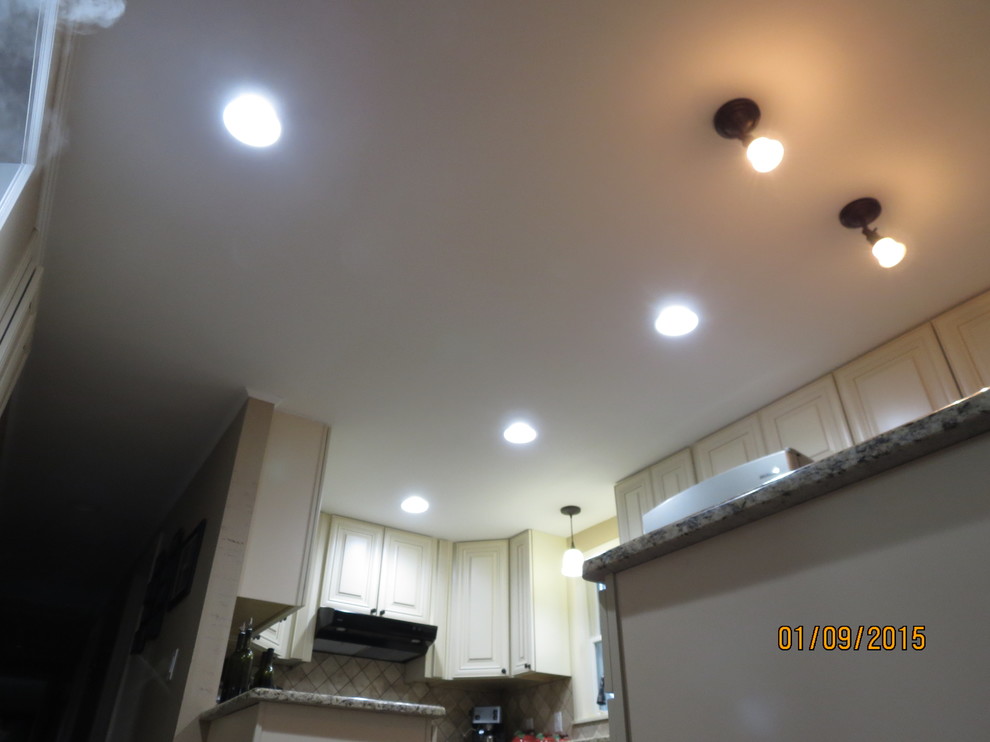 Example of a mid-sized u-shaped eat-in kitchen design in DC Metro with a double-bowl sink, raised-panel cabinets, white cabinets, granite countertops, beige backsplash, porcelain backsplash and stainless steel appliances