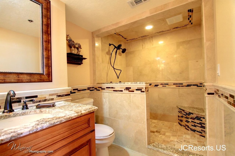 Design ideas for a mid-sized contemporary master bathroom in Tampa with raised-panel cabinets, medium wood cabinets, an open shower, a two-piece toilet, beige tile, stone tile, beige walls, marble floors, an undermount sink and granite benchtops.