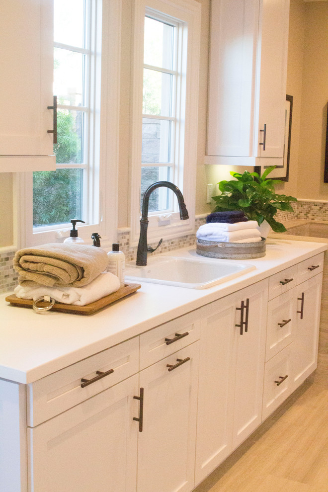 Inspiration for an expansive transitional u-shaped utility room in San Diego with shaker cabinets, white cabinets, quartzite benchtops, beige walls, porcelain floors and a side-by-side washer and dryer.