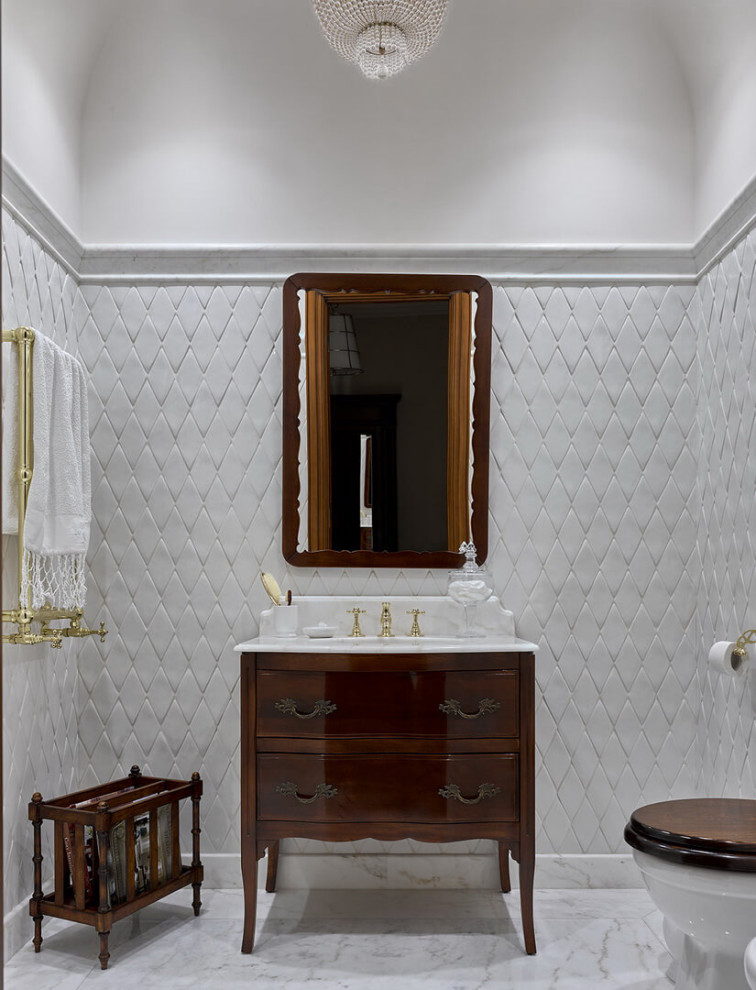 Стильный дизайн: туалет среднего размера в классическом стиле с темными деревянными фасадами, инсталляцией, керамической плиткой, мраморным полом, врезной раковиной, мраморной столешницей, напольной тумбой, сводчатым потолком, плоскими фасадами, белой плиткой, белыми стенами, белым полом и белой столешницей - последний тренд