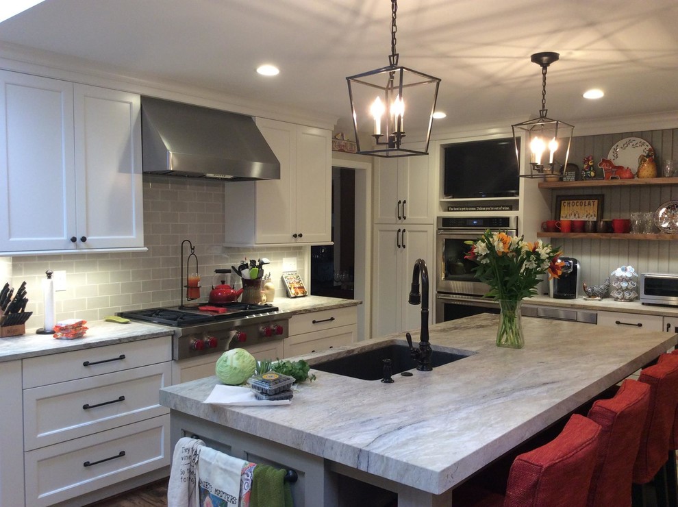 Example of a mid-sized transitional l-shaped light wood floor and brown floor eat-in kitchen design in Baltimore with an undermount sink, shaker cabinets, white cabinets, granite countertops, gray backsplash, porcelain backsplash, stainless steel appliances and an island