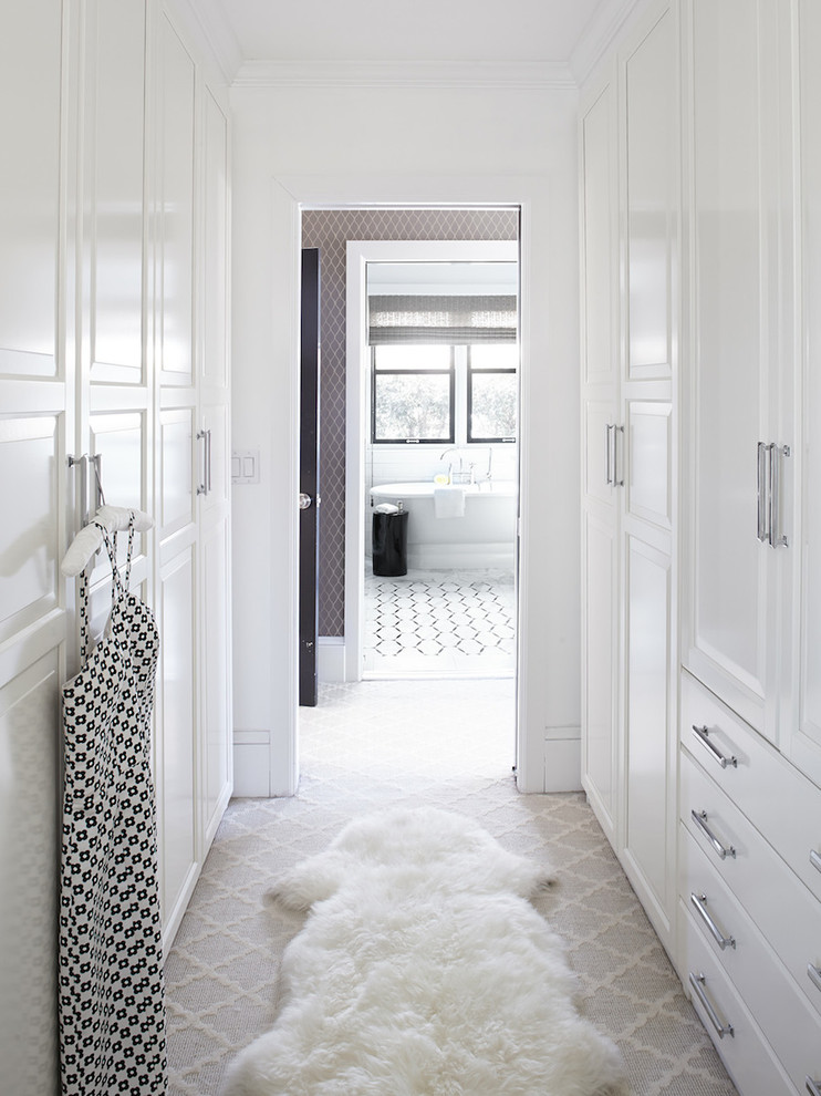This is an example of a large transitional women's walk-in wardrobe in San Francisco with raised-panel cabinets, white cabinets and carpet.