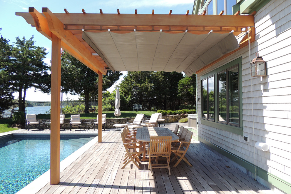 Large beach style backyard deck in Toronto with a pergola.