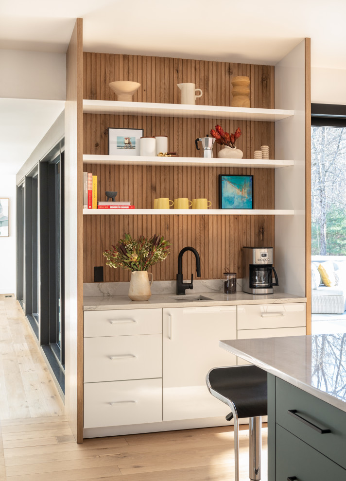 Inspiration for a mid-sized mid-century modern u-shaped light wood floor and vaulted ceiling open concept kitchen remodel in Boston with an undermount sink, flat-panel cabinets, quartzite countertops, stainless steel appliances, an island and white countertops