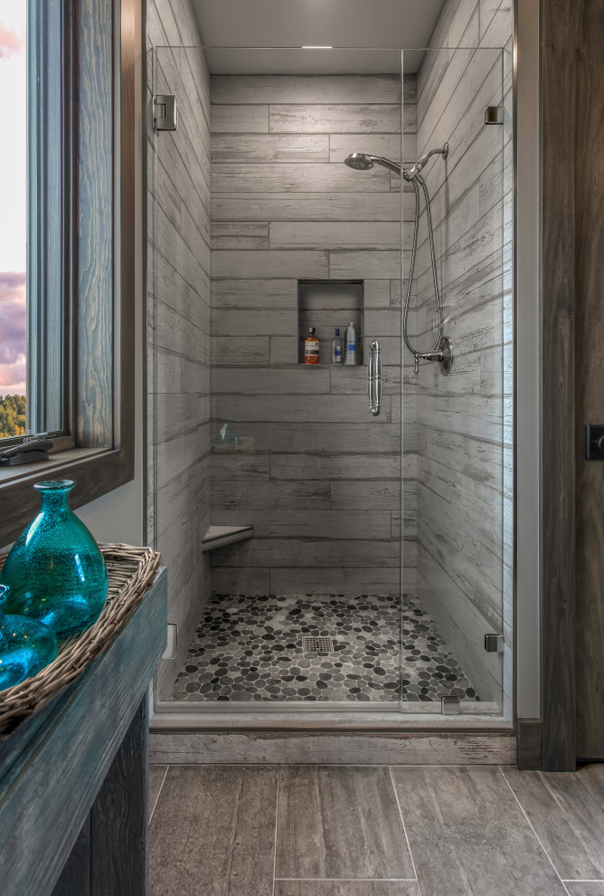 Inredning av ett amerikanskt stort svart svart badrum med dusch, med grå skåp, en dusch i en alkov, granitbänkskiva, dusch med gångjärnsdörr, grå kakel, ett integrerad handfat, grå väggar, cementgolv och grått golv