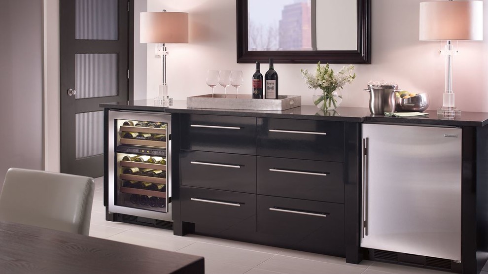 Photo of a small modern single-wall wet bar in Boston with flat-panel cabinets, black cabinets, solid surface benchtops, porcelain floors and grey floor.