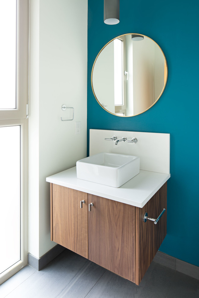 This is an example of a contemporary powder room in Seattle with flat-panel cabinets, medium wood cabinets, a wall-mount toilet and engineered quartz benchtops.