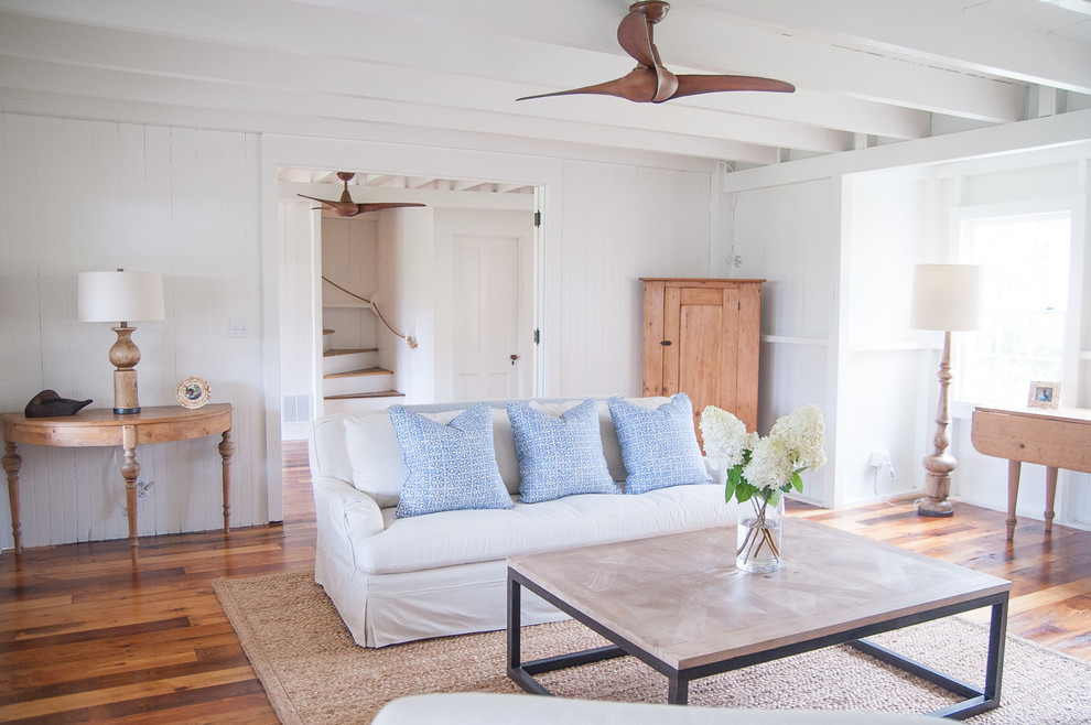 Large beach style formal and open concept medium tone wood floor living room photo with white walls, no tv, a standard fireplace and a brick fireplace