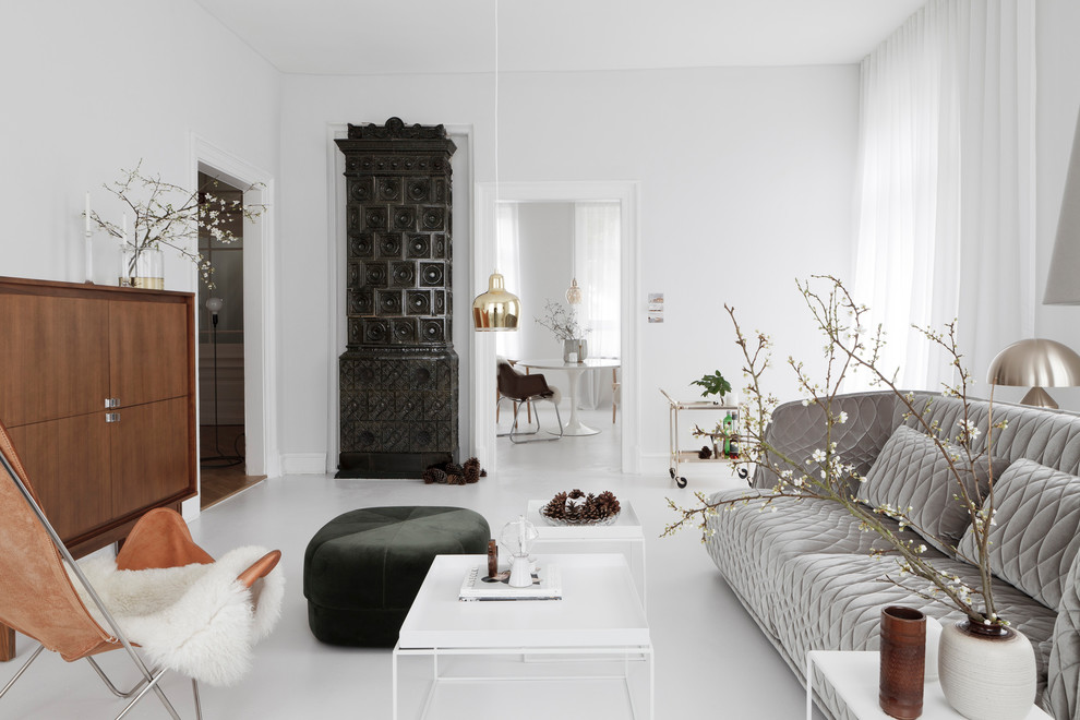 This is an example of a large contemporary formal enclosed living room in Frankfurt with white walls, concrete floors, a wood stove, a tile fireplace surround, no tv and white floor.