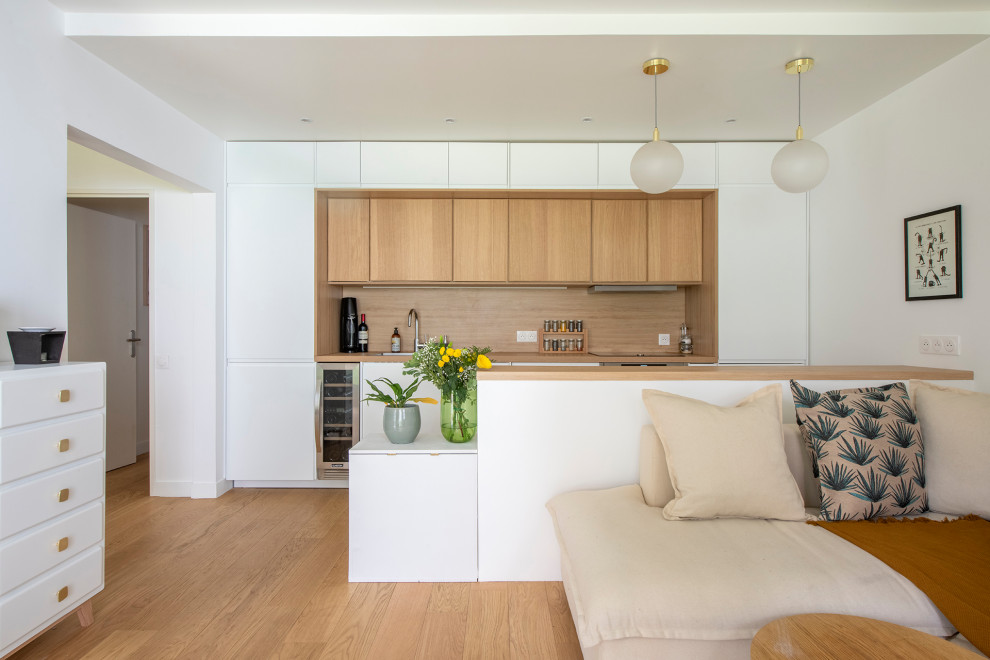 Diseño de sala de estar abierta moderna de tamaño medio sin chimenea con paredes blancas, suelo de madera clara, televisor independiente y suelo beige