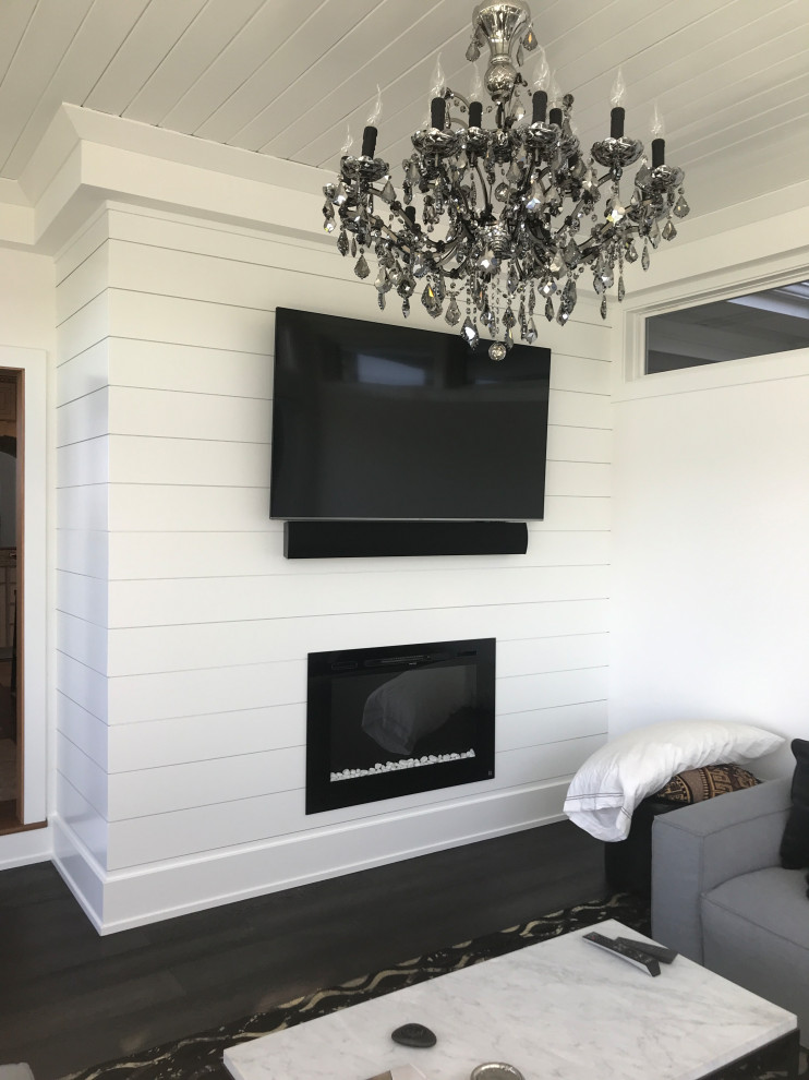 Foto di un soggiorno eclettico di medie dimensioni e chiuso con pareti beige, TV a parete, camino classico, soffitto in perlinato, parquet scuro e pavimento marrone