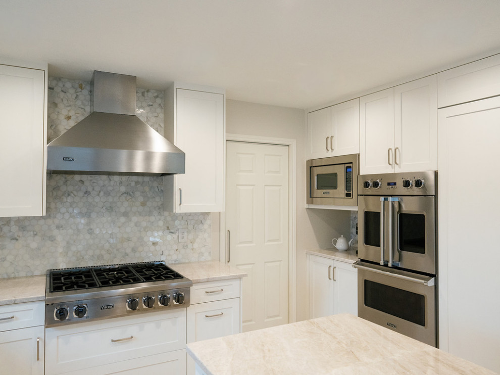 Inspiration for a large transitional u-shaped medium tone wood floor and brown floor enclosed kitchen remodel in Dallas with an undermount sink, raised-panel cabinets, beige cabinets, quartzite countertops, white backsplash, marble backsplash, stainless steel appliances, an island and beige countertops