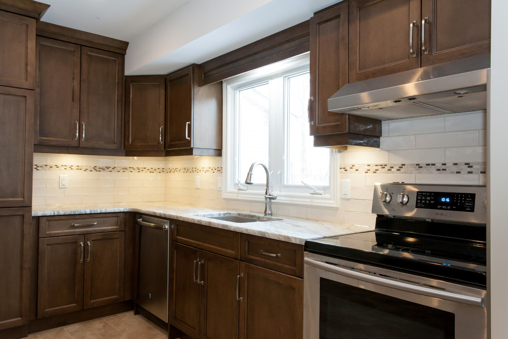 Example of a mid-sized transitional u-shaped porcelain tile eat-in kitchen design in Toronto with an undermount sink, recessed-panel cabinets, dark wood cabinets, granite countertops, white backsplash, porcelain backsplash, stainless steel appliances and a peninsula