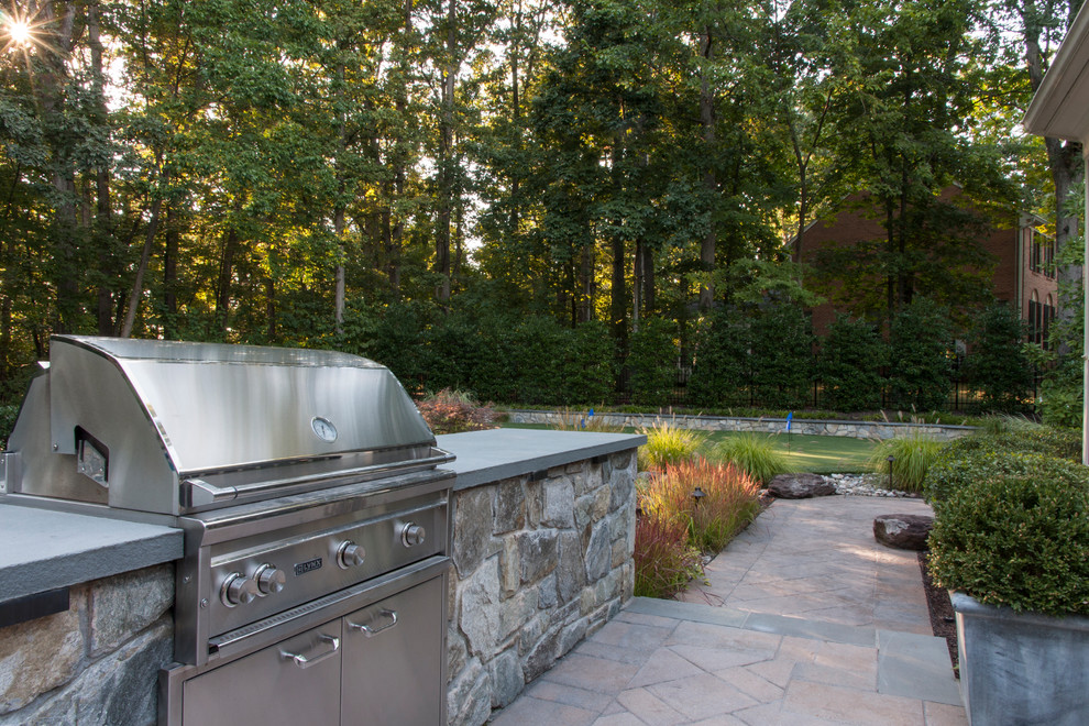 This is an example of a mid-sized eclectic backyard patio in DC Metro with an outdoor kitchen and concrete pavers.