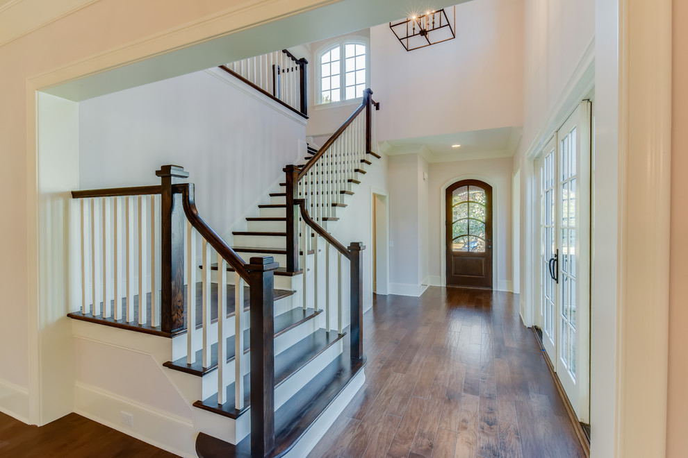 Example of a large transitional medium tone wood floor home design design in Charlotte with white walls and a dark wood front door