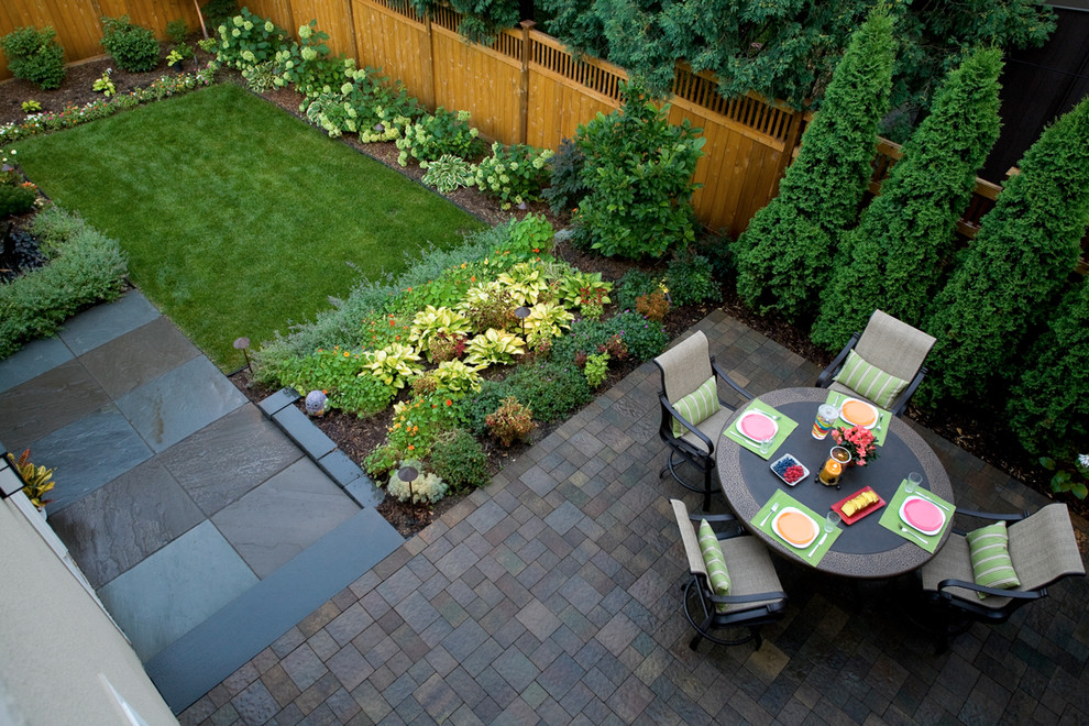 Traditional backyard garden in Minneapolis with natural stone pavers and a vegetable garden.