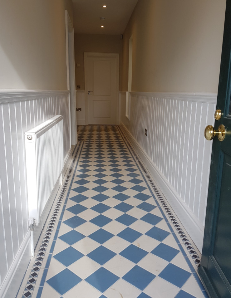 Traditional hallway in Other with white walls and porcelain floors.