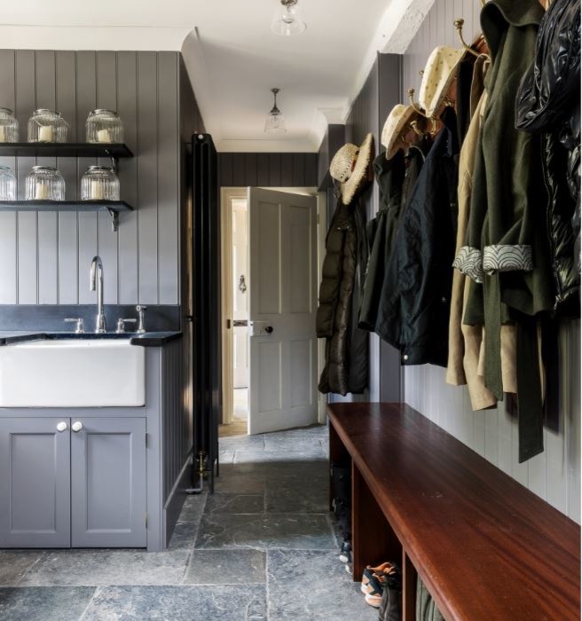 Inspiration for a large traditional utility room in London with a farmhouse sink, shaker cabinets, grey cabinets, granite benchtops, grey walls, slate floors, grey floor and black benchtop.