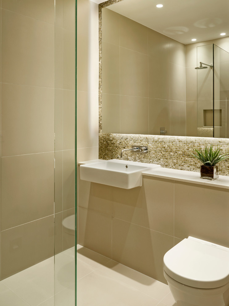 Photo of a mid-sized contemporary 3/4 bathroom in London with an open shower, a wall-mount toilet, beige walls, beige tile, porcelain tile, tile benchtops, a drop-in sink and an open shower.