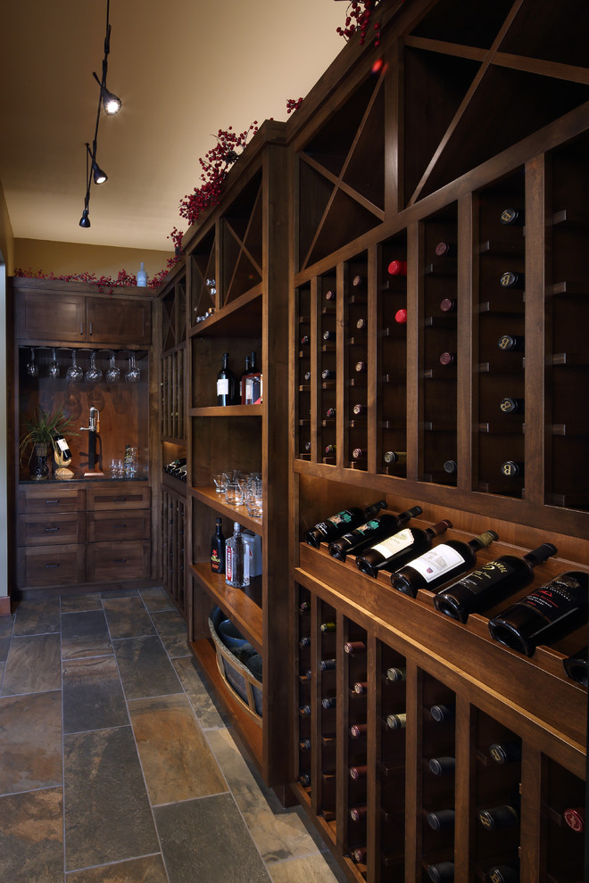 Photo of a mid-sized traditional wine cellar in Other with slate floors, storage racks and grey floor.